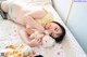 A woman laying on a bed with a teddy bear.