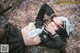 A woman laying on the ground with a sword in her hand.