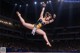 A woman in a leotard doing a trick in front of a crowd.