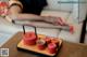 A woman laying on a couch next to a tray with cups of tea.