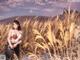 A woman standing in a field of tall grass.