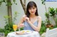 A woman sitting at a table with a plate of food and a glass of orange juice.