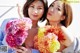 A couple of women holding a bunch of flowers.